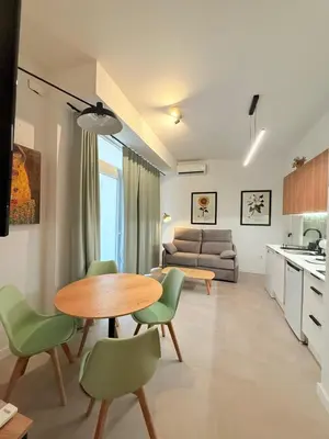 a kitchen and living room with a table and chairs at Travel Habitat Oceanografic Suites in Valencia