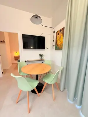 a dining room with a table and green chairs at Travel Habitat Oceanografic Suites in Valencia