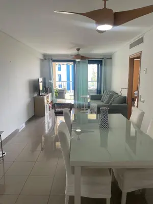 a dining room and living room with a table and chairs at Patacona beach apartment in Valencia