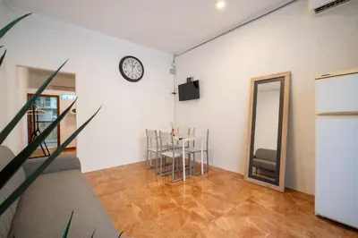 a room with a table and chairs and a clock on the wall at Loft Economico Cerca del Centro 1 Domitorio y Sofa cama 4pax AC in Valencia