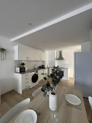 a kitchen with a table and chairs and a refrigerator at More than a lovely flat in Godella