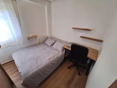 a small bedroom with a bed and a desk at Piso Burjassot - Valencia in Burjasot