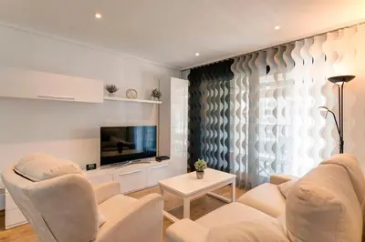 a living room with white furniture and a flat screen tv at Beach apartment in Valencia