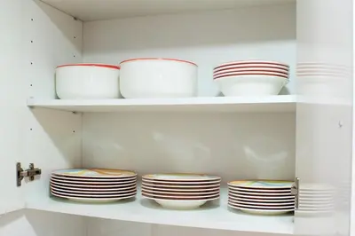 a group of plates and bowls on shelves in a kitchen at Beach apartment in Valencia