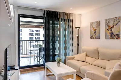 a living room with a couch and a tv at Beach apartment in Valencia