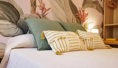 a bed with four pillows on top of it at Naturaloft in Valencia