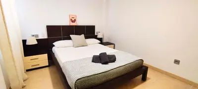 a bedroom with a bed with a black towel on it at Apartamento cerca Playa in Puerto de Sagunto
