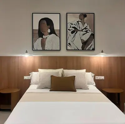 a bedroom with a bed with three paintings on the wall at Pivote Flats-Puerto B in Valencia
