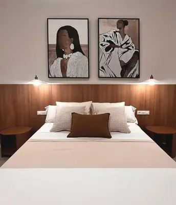 a bedroom with a white bed with three paintings on the wall at Pivote Flats-Puerto B in Valencia