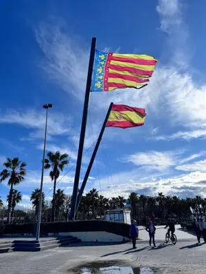 two flags on a pole with people on bikes at Estudio en Valencia in Valencia