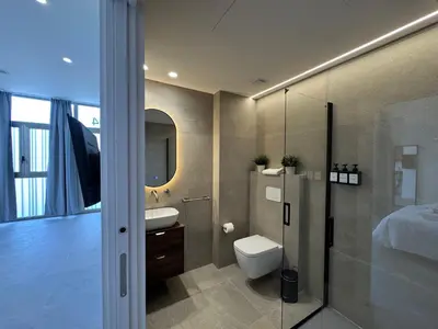 a bathroom with a toilet and a sink and a bed at Boutique Room - Plaza Tower in Valencia