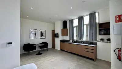 a room with a kitchen with a sink and a table at Boutique Room - Plaza Tower in Valencia