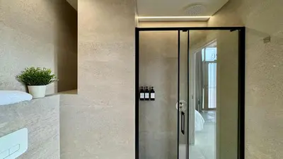 a glass shower door in a bathroom with wine bottles at Boutique Room - Plaza Tower in Valencia