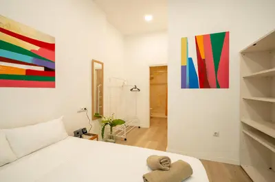 a bedroom with a bed and a painting on the wall at Loft Centrico 2 pax Poyector TV in Valencia