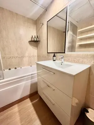 a white bathroom with a sink and a mirror at Beachfront Family Appartment with Pool in Valencia