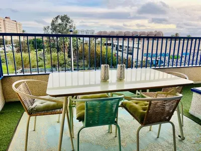 a table and chairs on a balcony with a view at Beachfront Family Appartment with Pool in Valencia