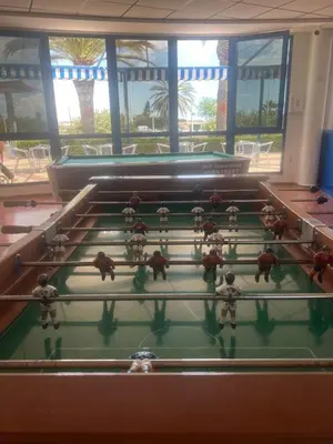 a group of people playing a game on a pool table at Beachfront Family Appartment with Pool in Valencia