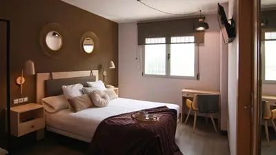 a bedroom with a bed and two mirrors on the wall at El Puig in El Puig
