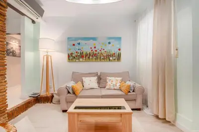 a living room with a couch and a painting on the wall at La Casa de las CestaS in Valencia