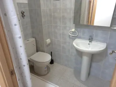 a bathroom with a white toilet and a sink at Estirpe, 4-7 in Cullera