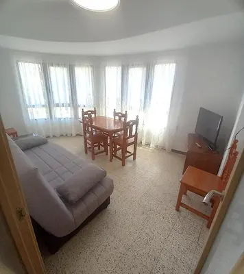 a living room with a bed and a table and chairs at Estirpe, 4-7 in Cullera