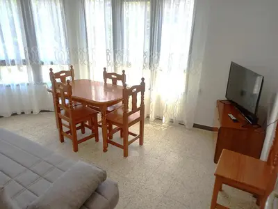 a room with a table and chairs and a television at Estirpe, 4-7 in Cullera