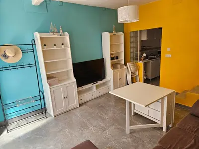 a living room with a tv and a table at Cosy house near the castle in Cullera