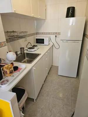 a small kitchen with a sink and a refrigerator at Cosy house near the castle in Cullera