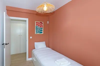 a small bedroom with orange walls and a bed at GuestReady - Lovely family home in El Cabanyal in Valencia