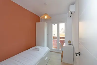 a small room with a bed and a window at GuestReady - Lovely family home in El Cabanyal in Valencia