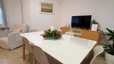 a living room with a white table and a tv at Villa Bobal in Requena