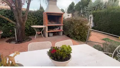 a table and chairs with a fireplace on a patio at Villa Bobal in Requena