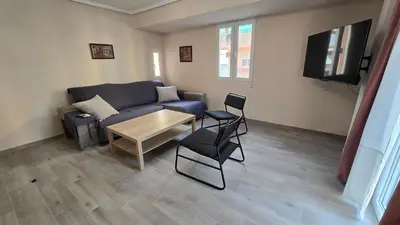 a living room with a couch and a table and a tv at Apartamento Musical in Cullera