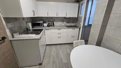 a kitchen with white cabinets and a stove top oven at Apartamento Musical in Cullera