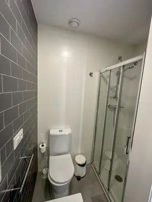 a bathroom with a toilet and a glass shower at El Coso in Valencia