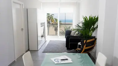 a living room with a table and chairs and a view of the ocean at El Coso in Valencia