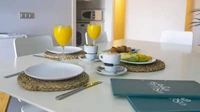 a table with two glasses of orange juice and plates of food at El Coso in Valencia