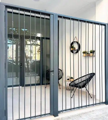 a balcony with glass doors and a black chair at Apartamento Estilo in Valencia