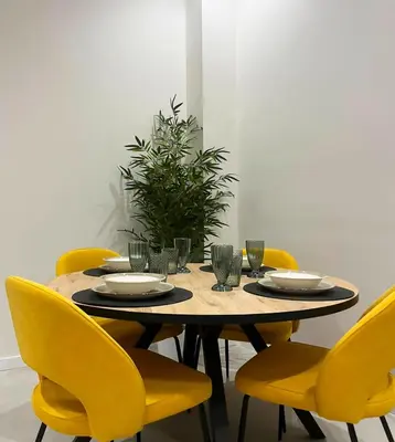 a dining room table with yellow chairs around it at Apartamento Estilo in Valencia