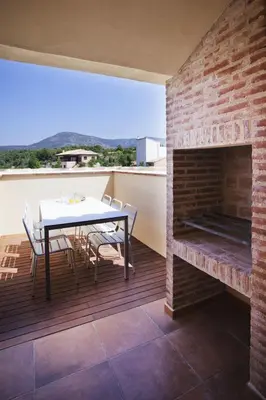 a patio with a table and a brick fireplace at El Rincon De Jara in Caudiel