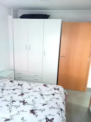 a bedroom with a bed and white cabinets at Nautic, 4-I in Cullera