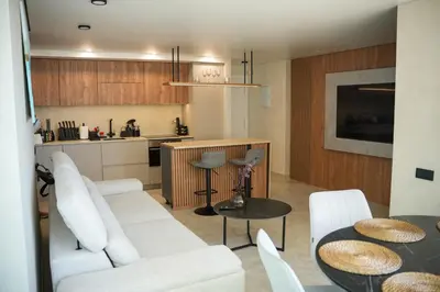 a kitchen and a living room with a table and chairs at Sucro Playa Apartment in Cullera