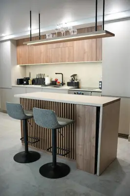 a kitchen with two bar stools and a counter at Sucro Playa Apartment in Cullera