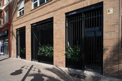 a brick building with two black doors with plants at Loft céntrico, 60 m2 ideal para familias pequeñas in Valencia