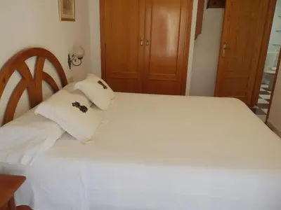 a bedroom with a white bed with white pillows at Navarrete, 4-20 in Cullera