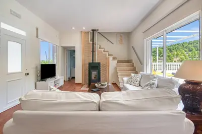 a living room with a white couch and a television at Lux Villa with Heating Pool, Air Conditioning, Starlink & BBQ near Cullera Beach in Llaurí
