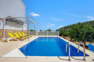 a swimming pool with yellow lounge chairs and a pool at Lux Villa with Heating Pool, Air Conditioning, Starlink & BBQ near Cullera Beach in Llaurí