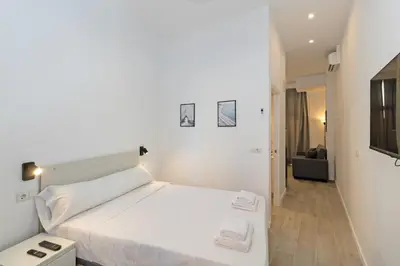 a white bedroom with a white bed and a couch at GuestReady - Bright home in Valencia in Valencia