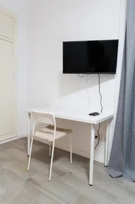 a white desk with a tv and a chair at GuestReady - Bright home in Valencia in Valencia