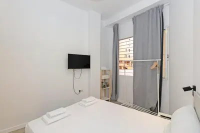 a white room with a bed and a window at GuestReady - Bright home in Valencia in Valencia